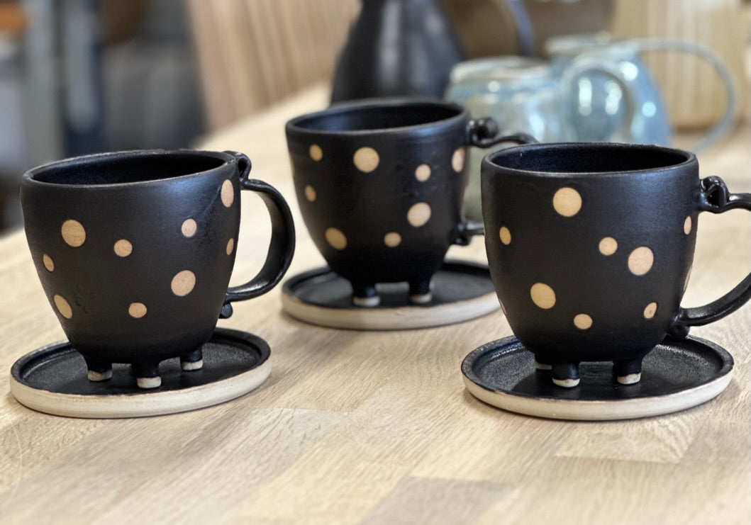 Sort krus med prikker og fødder + lille tallerken